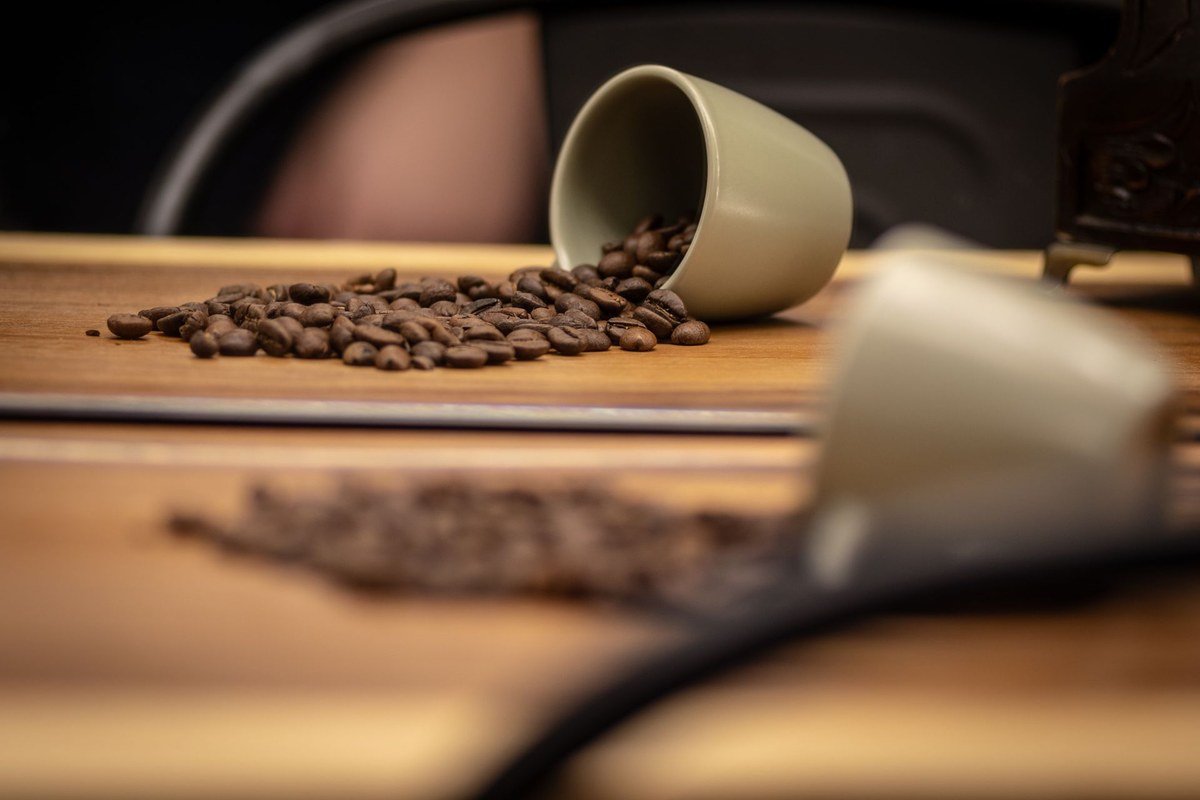 Spilled coffee beans beside an overturned cup — why coffee tannin stains are so stubborn
