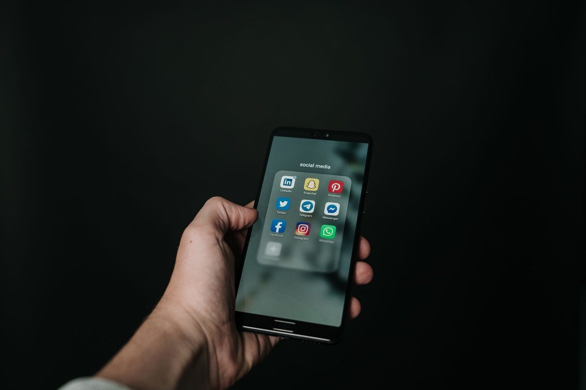 Hand holding smartphone — turn on spam protection to stop spam texts