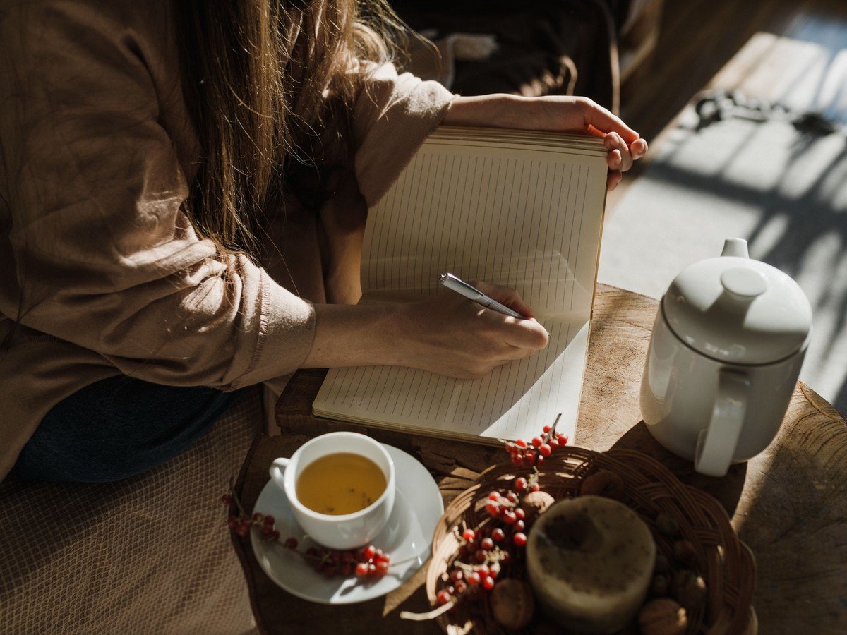 Person journaling in a notebook to stop overthinking (illustrative photo)