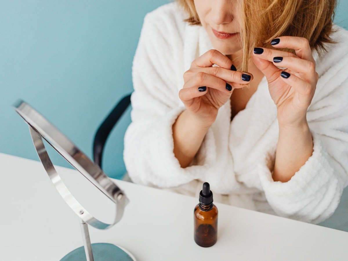 Woman applying hair oil to reduce hair fall (illustrative photo)