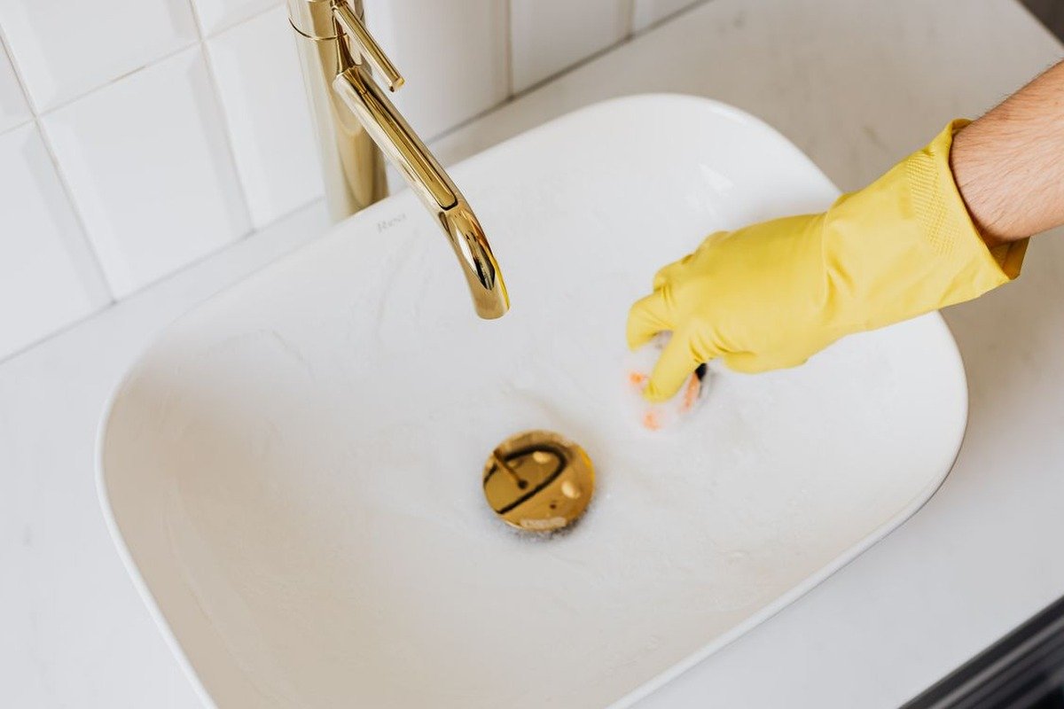 Using a drain snake tool to unclog a sink drain