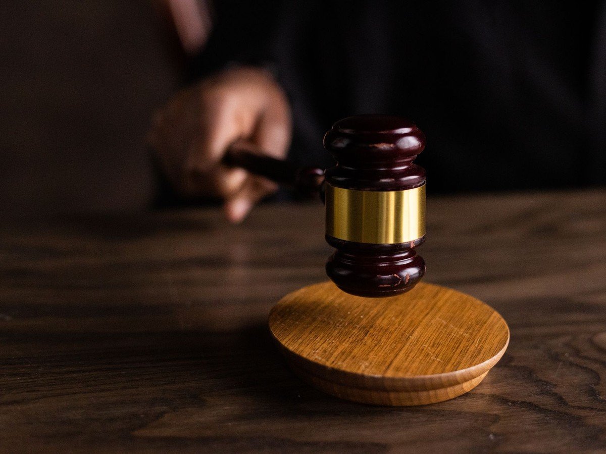 A judge's gavel mid-strike on a dark wood desk - the sentencing in the Robinson brothers murder case is set for October 16