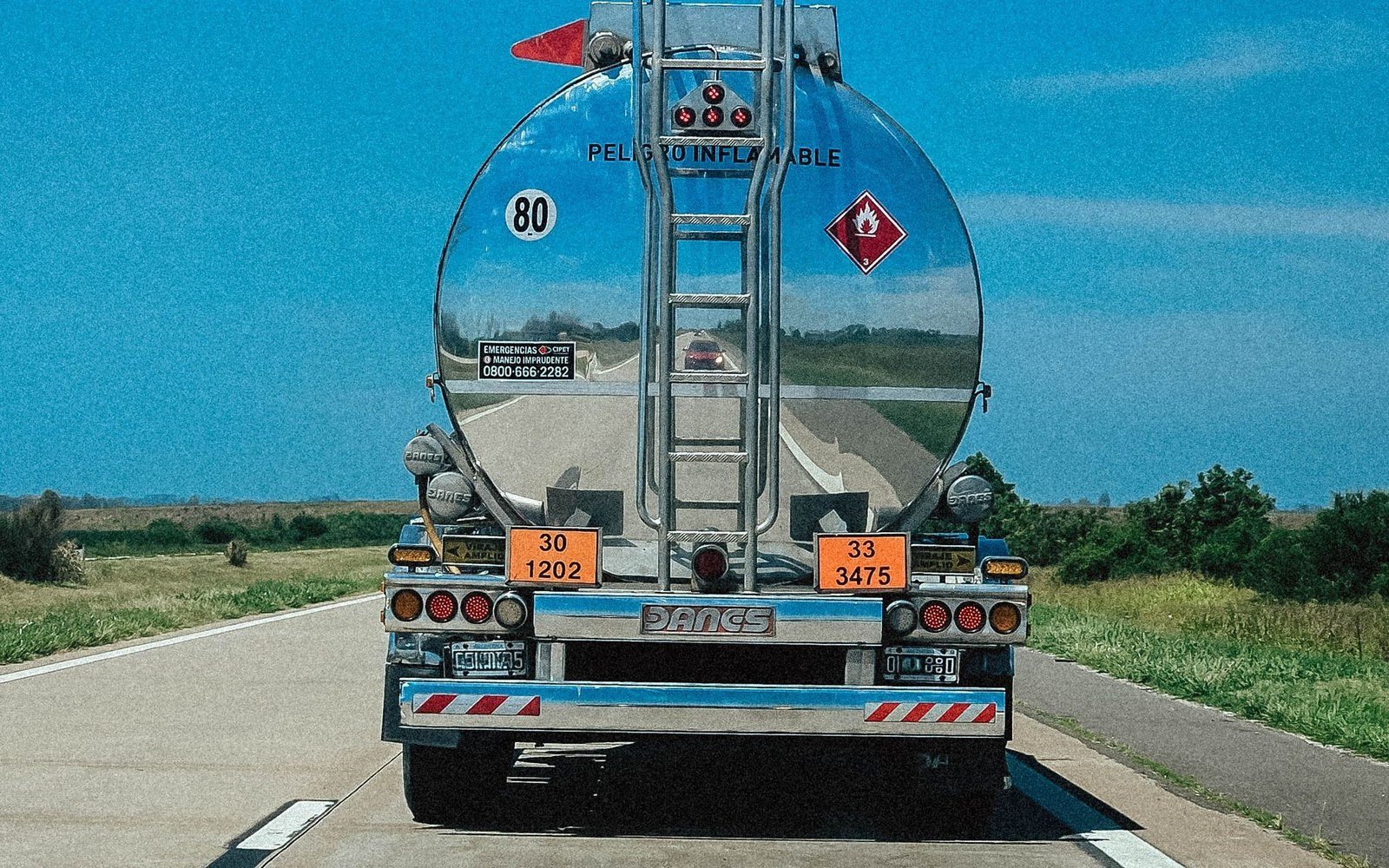 Fuel tanker truck driving on a highway, part of the diesel supply chain driving record fuel costs