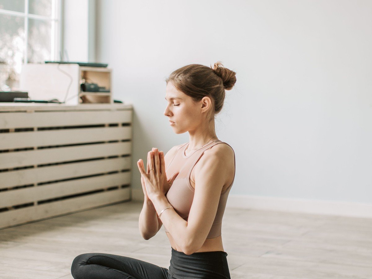 Woman practicing calming breathing meditation to stop overthinking (illustrative photo)