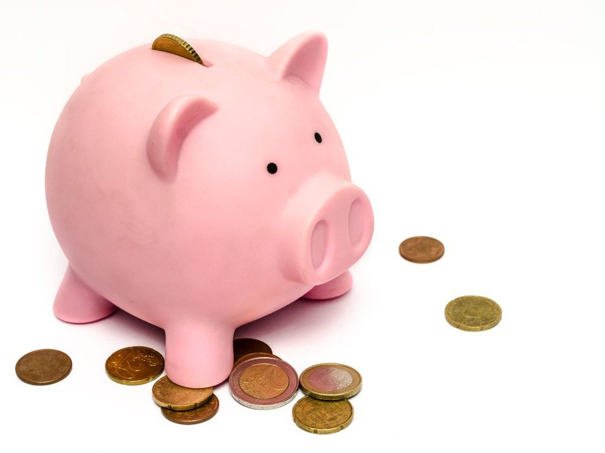 Pink piggy bank with coins — building savings on a tight budget