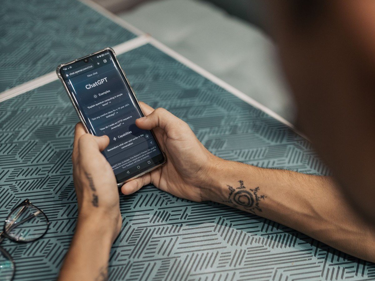 Hands holding a smartphone with ChatGPT open on the screen