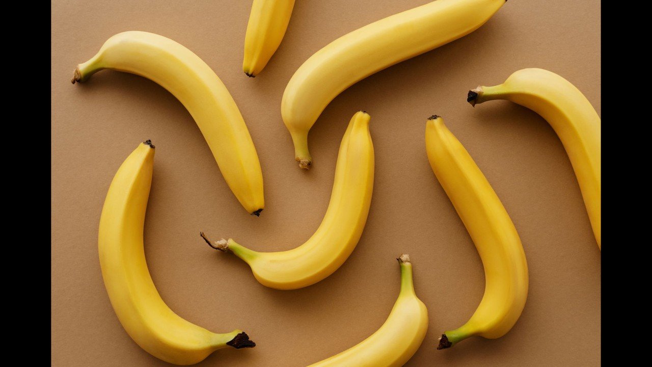 Fresh yellow bananas arranged on a kitchen counter