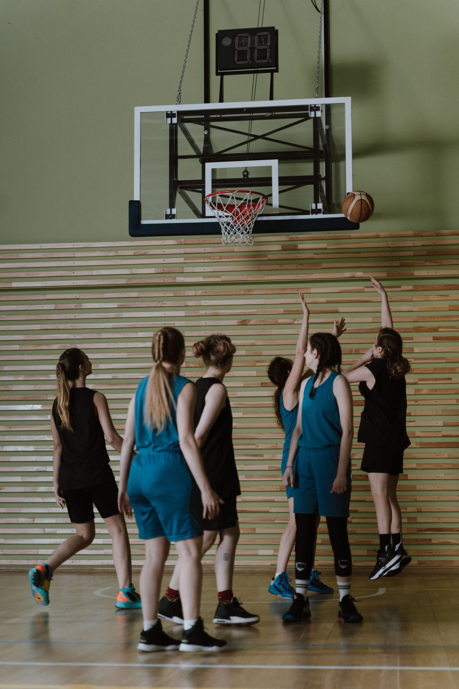 Women playing basketball indoors during a competitive game.