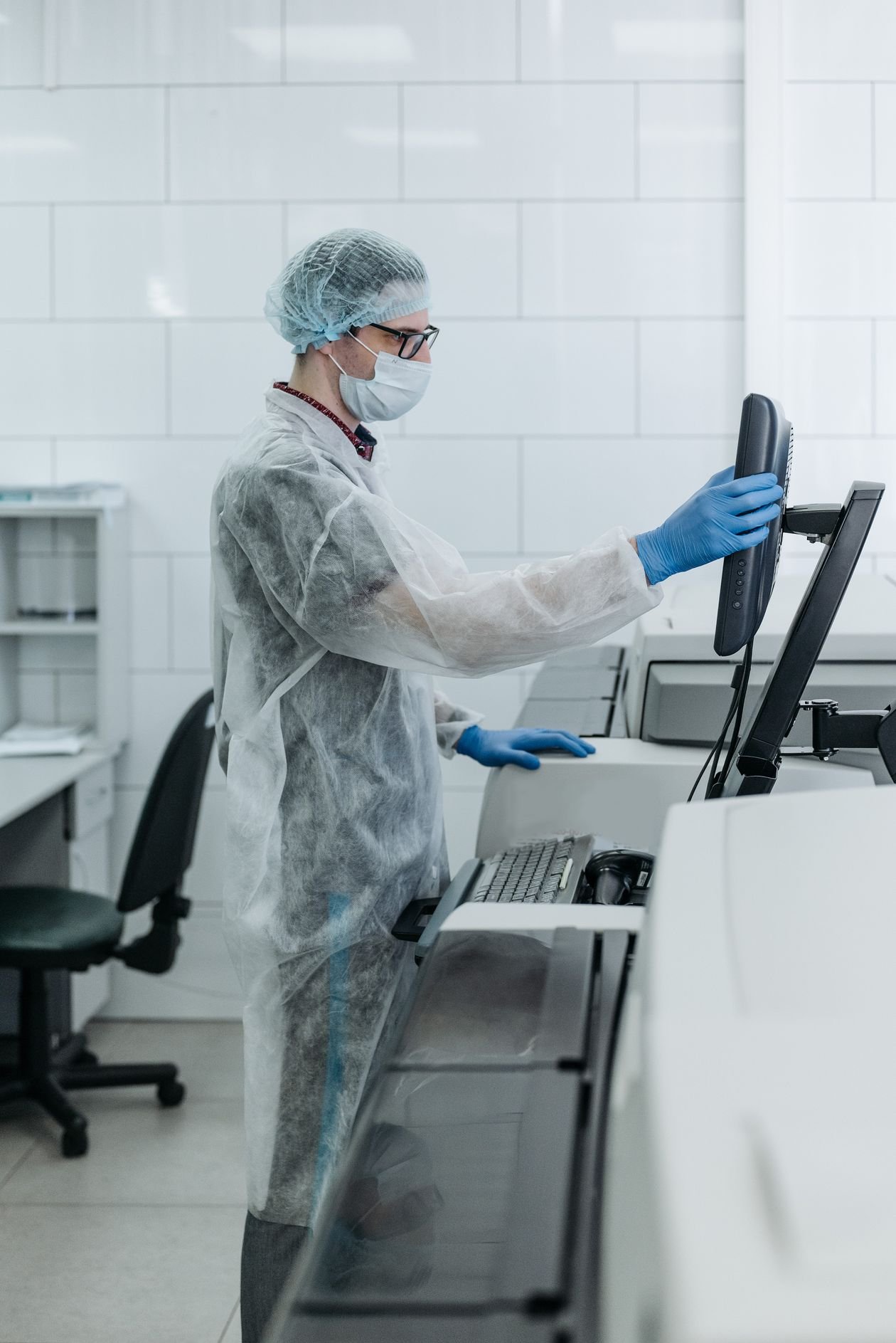Chemist in protective gear analyzing laboratory samples, the kind of modern lab work recognized by the 2026 Nobel Prize in Chemistry