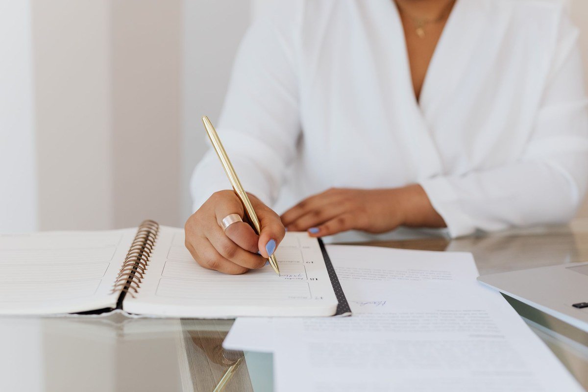 Person writing in a planner to beat procrastination with daily planning